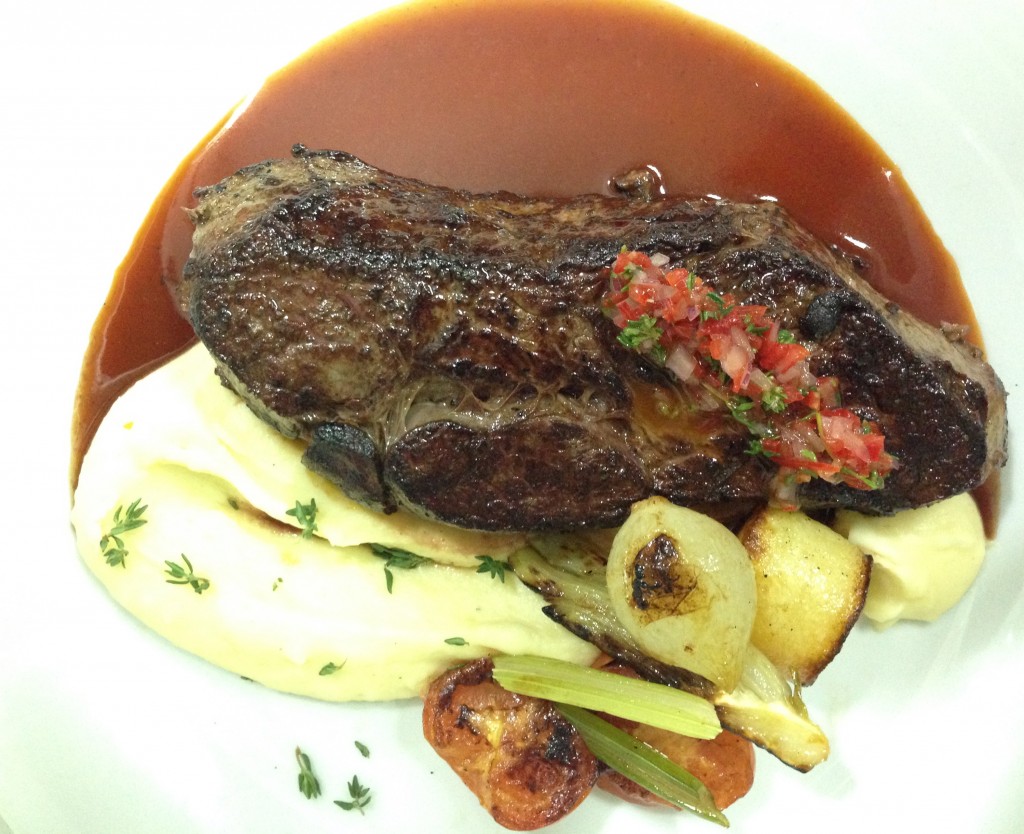 Churrasco de cuadril con crema de papas y tomillo, jugo de carne y cebollas asadas